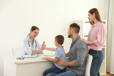 Parents and son visiting pediatrician. Doctor working with patient in hospital