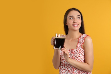 Beautiful woman with cold kvass on yellow background. Traditional Russian summer drink