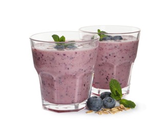Tasty blueberry smoothie with oatmeal in glasses on white background