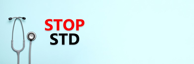 Text STOP STD and stethoscope on light blue background, top view with space for text. Banner design