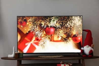 Photo of Modern TV and Christmas decor on table indoors