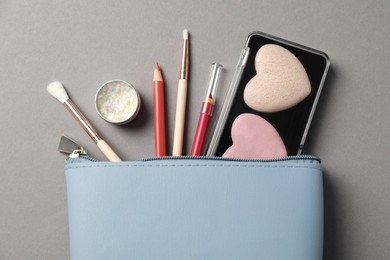 Set of makeup products with bag on grey background, flat lay
