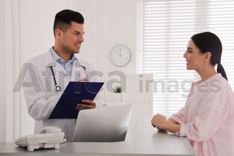 Photo of Doctor working with patient at reception in hospital