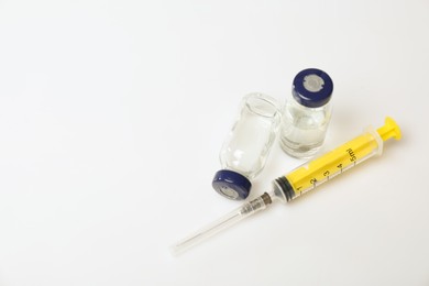 Syringe and vials on white background, above view. Space for text
