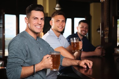 Happy friends with tasty beer in pub