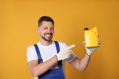Man pointing at yellow container of motor oil on orange background