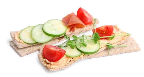 Photo of Tasty crispbreads with cream cheese and fresh vegetables isolated on white