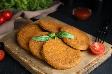 Photo of Delicious fried breaded cutlets served on black table, closeup