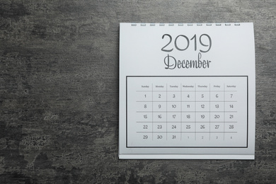 December 2019 calendar on grey stone background, top view. Space for text
