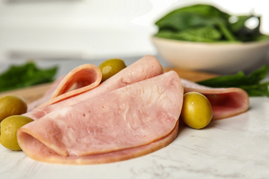 Ham with olives and spinach on table, closeup