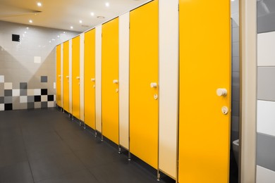 Public toilet interior with bright yellow stalls