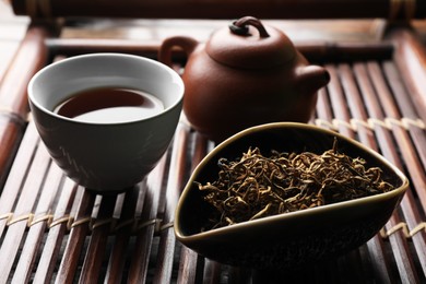Photo of Aromatic Dianhong tea on wooden tray, closeup. Traditional ceremony