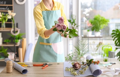 Photo of Female florist with roses at workplace