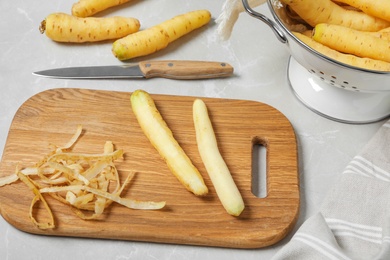 Peeled white carrots on wooden cutting board