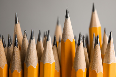 Many graphite pencils on grey background, closeup
