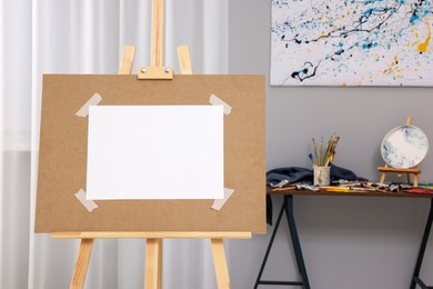 Photo of Wooden easel with taped paper in artist's studio