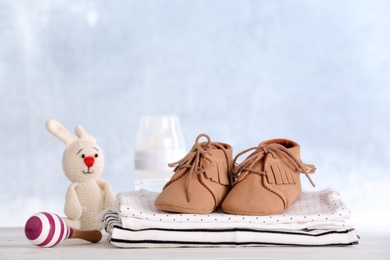 Set with baby accessories on table against light background