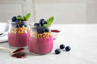 Tasty dessert with acai smoothie, granola and berries on marble table. Space for text