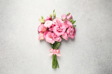 Beautiful bouquet of pink Eustoma flowers on light grey background, top view