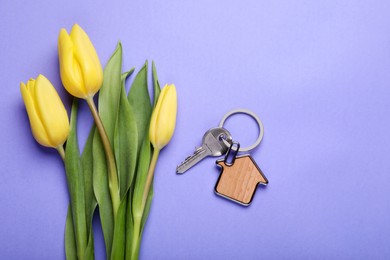 Photo of Beautiful spring flowers and key with trinket in shape of house on violet background, flat lay