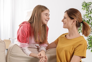 Young mother talking with her teenager daughter at home