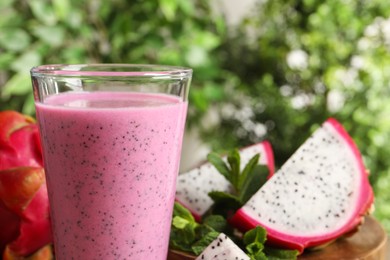 Delicious pitahaya smoothie and fresh fruits on blurred background, closeup. Space for text