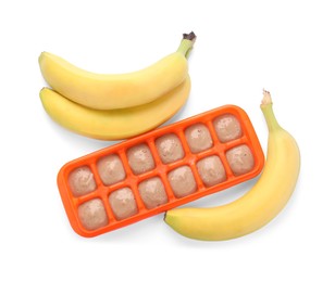 Banana puree in ice cube tray and fresh banana fruits isolated on white, top view
