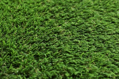 Photo of Green artificial grass texture as background, closeup