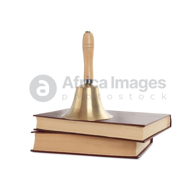 Golden school bell with wooden handle and books on white background