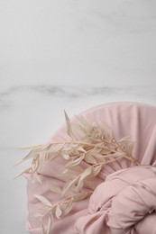 Photo of Furoshiki technique. Gift packed in pink fabric and dried branches on white marble table, top view. Space for text