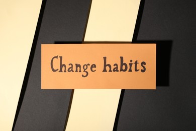 Paper note with phrase Change Habits on color background, top view
