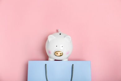 Flat lay composition with shopping bag and piggy bank on color background