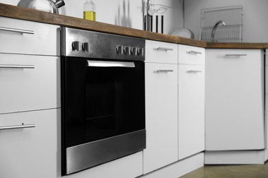 Photo of Modern electric oven in kitchen. Domestic appliance