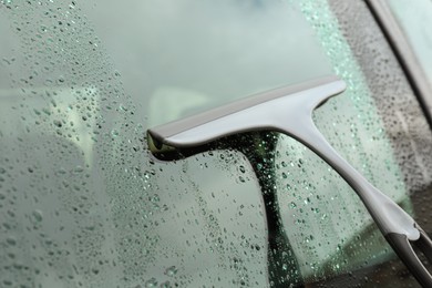 Photo of Wiping car window with drying blade outdoors, closeup