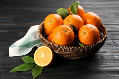 Delicious ripe oranges on black wooden table