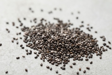 Photo of Pile of chia seeds on light grey table, closeup