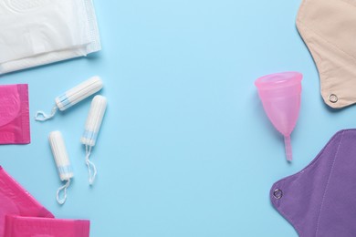 Different menstrual hygiene products on light blue background, flat lay. Space for text