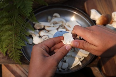 Man slicing mushrooms at table, closeup view
