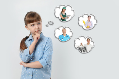 Thoughtful little girl choosing future profession on light background
