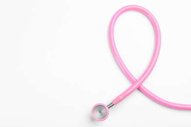 Pink stethoscope isolated on white, top view. Breast cancer awareness