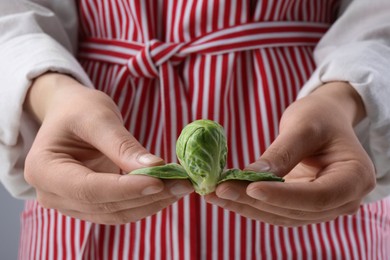 Woman separating leaves from fresh brussel sprout, closeup