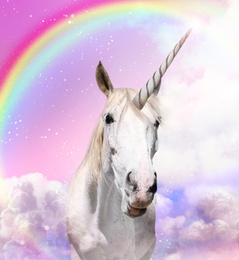 Magic unicorn in beautiful sky with rainbow and fluffy clouds. Fantasy world