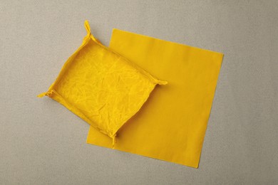 Orange reusable beeswax food wraps on grey background, top view