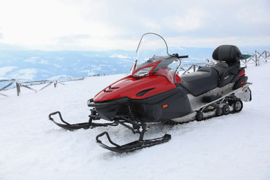 Modern snowmobile on hill at mountain ski resort
