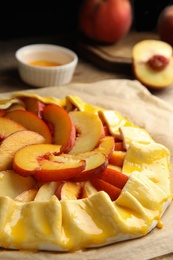 Uncooked peach pie on wooden table, closeup