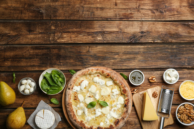 Tasty cheese pizza and ingredients on wooden table, flat lay. Space for text