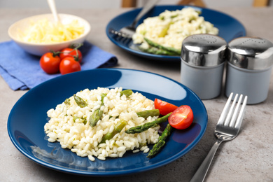Delicious risotto with asparagus on grey table