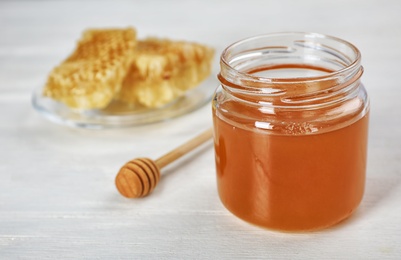 Jar of honey and dipper on table