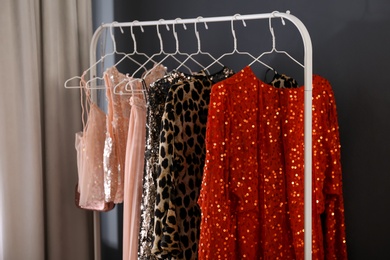 Rack with collection of beautiful festive clothes indoors