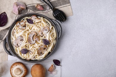 Delicious pasta with mushrooms served on grey table, flat lay. Space for text